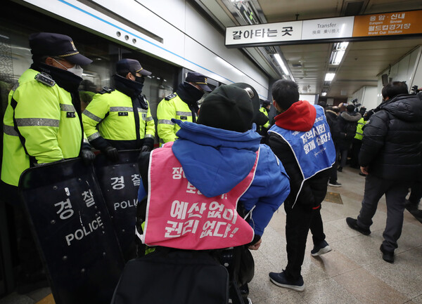 전국장애인차별철폐연대(전장연) 회원들이 14일 오전 서울 용산구 삼각지역에서 지하철 탑승 시위를 하고 있다. 이날 전장연 회원들의 지하철 내 사다리 반입 시도로 당고개 방면 열차 1대가 무정차 통과했다. 2022.12.14/뉴스1