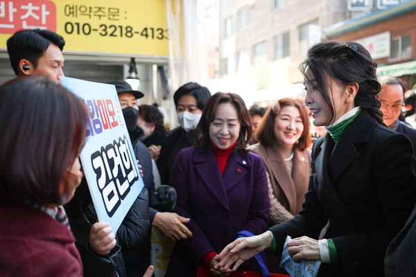 윤석열 대통령 부인 김건희 여사가 11일 오후 대구 중구 서문시장을 찾아 '최강미모 김건희'라고 쓰인 피켓을 바라보고 있다. (대통령실 제공) 2023.1.11&nbsp;ⓒ뉴스1