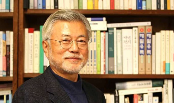 평산마을 사저의 책장에서 책을 꺼내 보고 있는 문재인 전 대통령.&nbsp;ⓒ한길사 제공