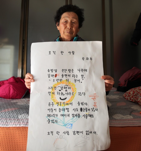 황화자 할머니가 사별한 남편에 대한 그리움을 담은 시화 '오직 한 사람'을 들어보이고 있다.&nbsp;ⓒ박종식 기자 제공