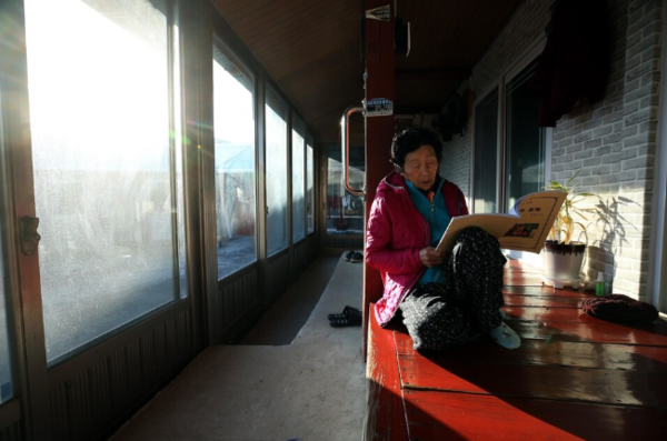 황화자 할머니가 툇마루에서 자서전을 소리내어 읽고 있다.&nbsp;ⓒ박종식 기자 제공