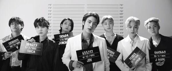 방탄소년단 ‘Butter’ MV 머그샷 장면, 멤버 정국은 자신의 서울 상경 날짜를 들고 있다.&nbsp;ⓒHYBE LABELS