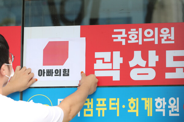 29일 오전 대구경북대학생진보연합 회원들이 아들의 퇴직금 50억원 논란으로 국민의힘을 탈당한 대구 남구 곽상도 의원 지역구 사무실 앞에서 국회의원 사퇴요구 기자회견을 마친 뒤 국민의힘 당 로고 위에 '아빠의힘'이라고 쓰여진 로고를 붙이고 있다. 2021.9.29 ⓒ뉴스1