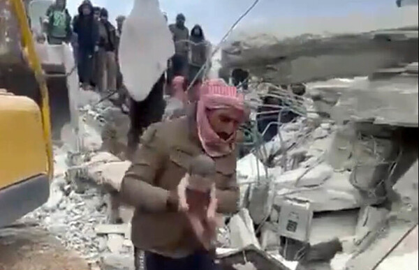 지난 6일(현지시각) 시리아 북서부 알레포주 아프린시 진데리스의 건물 잔해에서 먼지를 뒤집어 쓴 채 구조되는 아프라의 모습. ⓒ사회관계망서비스 갈무리