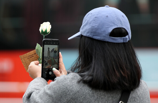 8일 오전 서울 광화문광장에서 한 시민이 세계여성의 날을 맞아 전달 받은 장미꽃을 손에 들고 기념사진을 찍고 있다. (2023.3.8)&nbsp;ⓒ뉴스1