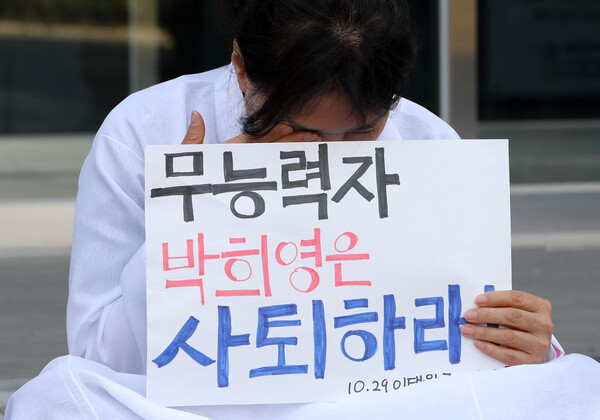 12일 이태원 참사 유가족이 용산구청 앞에서 박희영 용산구청장 사퇴 촉구 기자회견을 마친 뒤 손피켓을 든 채 울먹이고 있다.&nbsp;ⓒ뉴스1