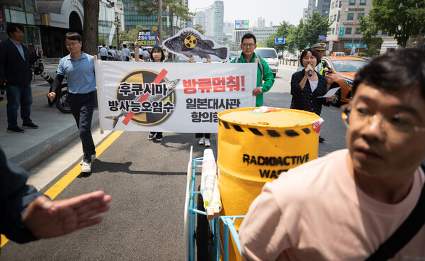 일본 방사성 오염수 해양투기 저지 서울행동 회원들이 15일 서울 서대문역에서 열린 일본 후쿠시마 오염수 방류 중단 항의 기자회견에서 방사능 드럼통을 운반하는 퍼포먼스를 하며 일본 대사관으로 행진하고 있다. 2023.6.15ⓒ뉴스1