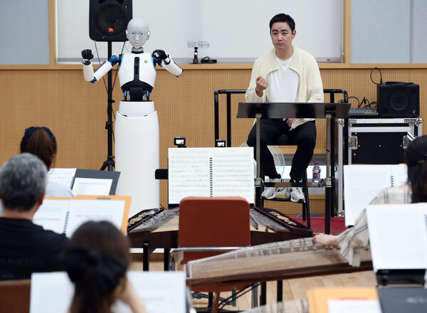 최수열 지휘자(오른쪽)가 26일 오후 서울 중구 장충동 국립극장 해오름극장 관현악단 연습실에서 국내 최초 지휘하는 로봇 '에버 6'와 비얌바수렌 샤라브 작곡의 '깨어난 초원' 무대를 함께하고 있다. 2023.6.26 ©뉴스1