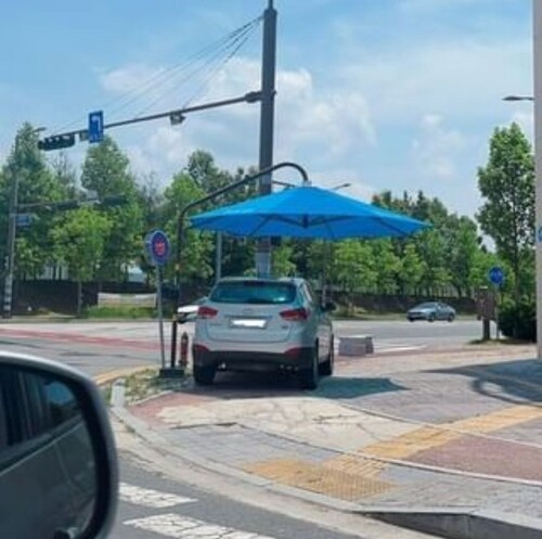 한 시민이 전남 나주의 거리에서 횡단보도 앞 그늘막 아래 주차된 차량을 촬영한 사진. ⓒ온라인 커뮤니티 갈무리