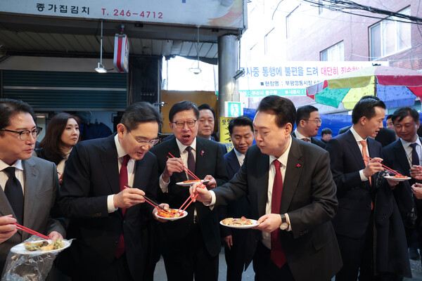 6일 부산 중구 깡통시장을 방문한 윤석열 대통령이 이재용 삼성전자 회장에게 떡볶이를 건네고 있다. (대통령실 제공) 2023.12.6. ⓒ뉴스1
