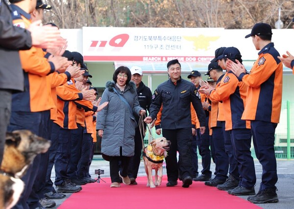 19일 경기도북부특수대응단 119구조견센터에서 열린 구조견 '아롱'의 은퇴식. 구조대원들의 축하를 받으며 '아롱'이 행사장을 나서고 있다. ⓒ경기도 제공