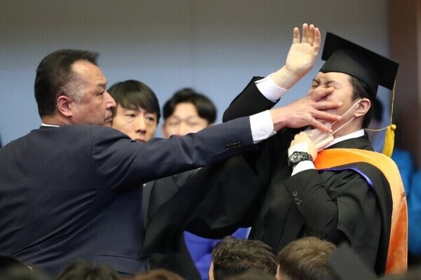2월16일 대전 유성구 한국과학기술원(KAIST) 학위수여식 도중 졸업생 신민기씨가 “알앤디 예산 복원하십시오”라고 소리치는 순간 경호원이 입을 막으며 제지하고 있다. ⓒ대전충남사진공동취재단/한겨레