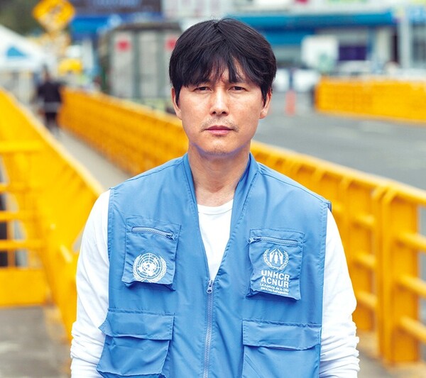 정우성 유엔난민기구(UNHCR) 친선대사가 지난달 21일 콜롬비아 남부 국경도시 이피알레스에서 에콰도르로 건너가는 루미차카 다리를 배경으로 사진을 찍고 있다.&nbsp;ⓒUNHCR