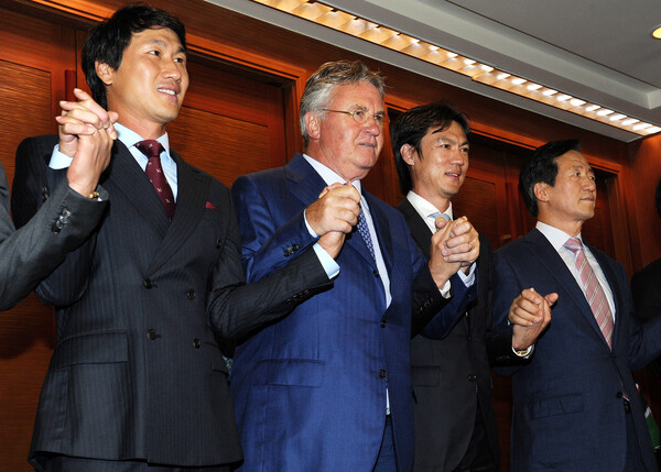 4일 서울 소공동 롯데호텔에서 열린 2002월드컵 10주년 기념식에 참석한 정몽준 대한축구협회 명예회장과 거스 히딩크 전 국가대표 축구팀 감독과 2002월드컵 4강신화의 주역인 전 국가대표 선수들이 손을 잡고 포즈를 취하고 있다. 왼쪽부터 유상철(대전시티즌 감독), 거스 히딩크 감독, 홍명보(올림틱 대표팀 감독) 2012.7.4ⓒ뉴스1