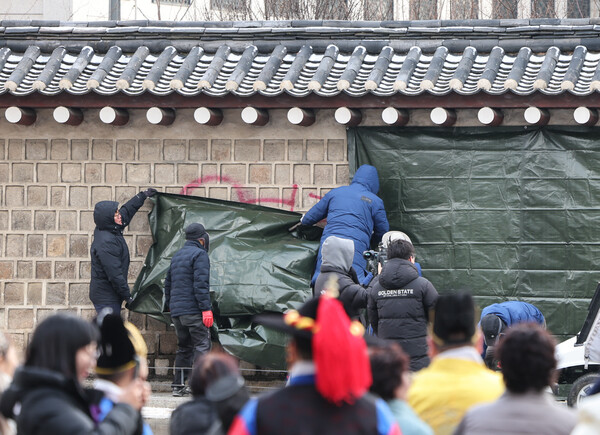 경복궁 관리소 직원들이 2023년 12월16일 경복궁 담장에 낙서로 훼손된 부분을 천막으로 가리는 모습.&nbsp;ⓒ뉴스1&nbsp;