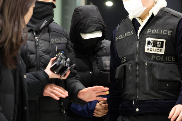 경복궁 담장에 스프레이로 불법 영상 공유 사이트 이름 등을 낙서 후 도주한 혐의를 받는 피의자 10대가 2023년 12월19일 서울 종로경찰서에 붙잡혀 들어오는 모습.&nbsp;ⓒ뉴스1&nbsp;