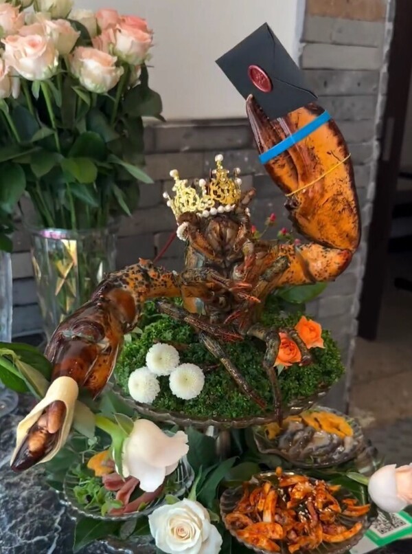 서울의 한 음식점에서 제공한 랍스터. 머리에 왕관을 쓴 채 한쪽 집게발엔 흰 장미를, 다른쪽엔 봉투를 들고 있게끔 '플레이팅'됐다. ⓒ온라인 커뮤니티