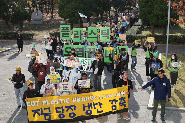 유엔 플라스틱 협약 제5차 정부 간 협상위원회 회의를 이틀 앞둔 23일 오후 부산 해운대구 올림픽공원 일대에서 열린 ‘1123 부산 플라스틱 행진’ 참가자들이 손팻말을 들고 회의가 열리는 벡스코를 향해 행진하고 있다. ⓒ한겨레