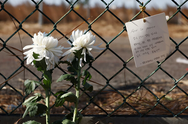 31일 전남 무안국제공항 제주항공 여객기 참사 현장에 국립한국교통대학교 비행훈련원 정비팀이 쓴 편지와 국화가 놓여 있다.