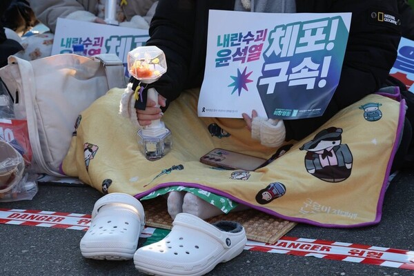 범시민총궐기대회가 열린 11일 오후 서울 종로구 광화문 동십자각 일대에서 한 집회 참석자가 발에 핫팩을 올려놓고 있다.&nbsp;ⓒ한겨레&nbsp;