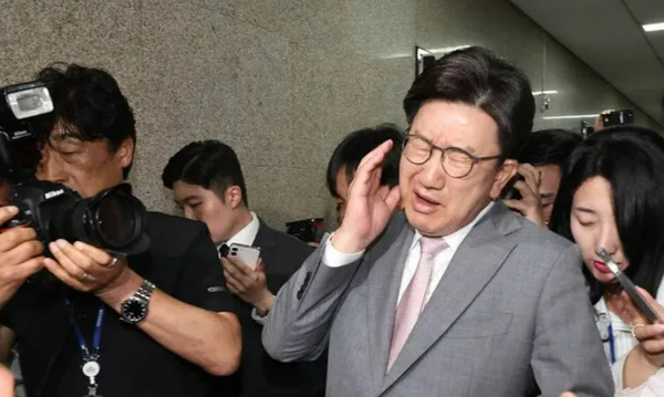 카메라에 뺨을 맞고 고통스러워 하는 권성동. ⓒ한겨레