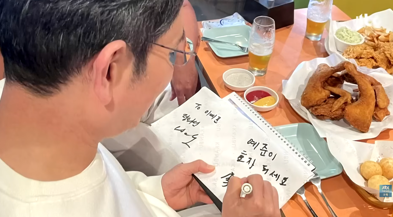 이재용이 깐부치킨에서 만난 어린이에게 사인을 남겨주고 있다. ⓒ유튜브 채널 ‘JTBC News’