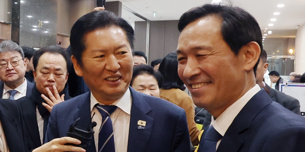 우상호 전 청와대 정무수석비서관(오른쪽)이 4일 당원 대상 특별 강연을 위해 강원 춘천시 스카이 컨벤션에 도착한 정청래 더불어민주당 대표와 악수하고 있다. ⓒ 연합뉴스