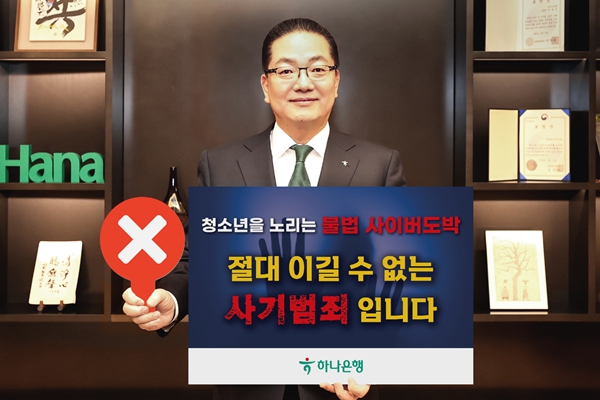 이호성 하나은행장이 서울 중구 하나은행 을지로 본점에서 청소년 불법도박 근절 릴레이 캠페인에 동참하기 위해 '청소년을 노리는 불법 사이버 도박, 절대 이길 수 없는 사기 범죄입니다'라는 메시지를 담은 피켓을 들고 사진을 촬영하고 있다. ⓒ하나은행
